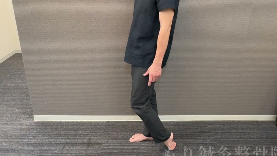 立った状態で足の甲を床につけ、ふくらはぎを縮めるストレッチ（横から見た全身）