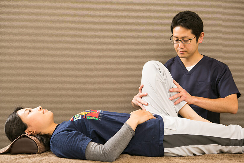 仰向けに寝た方の片膝を曲げ、太ももと骨盤を支えているところ